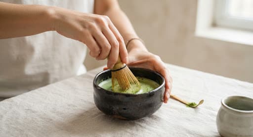 Bamboo whisk over a bowl of bright green Seijaku ceremonial matcha